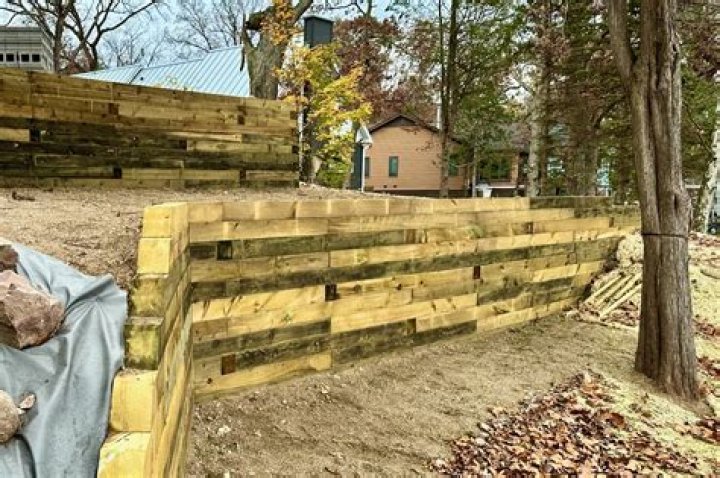 How do you landscape a retaining wall timber?